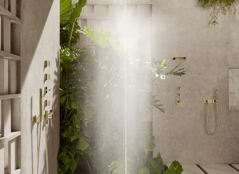 Ein luxuriöser, moderner hellbeiger Duschbereich mit Regendusche Serenity Sky von Dornbracht und grünen Pflanzen.