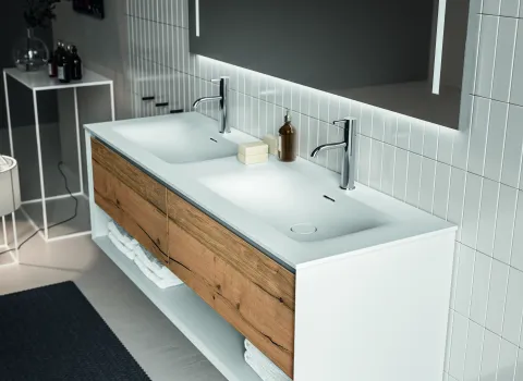 Stocco-Waschtisch Iks Up mit heller Holzfront und weißem Rahmen unter großem Leuchtspiegel.